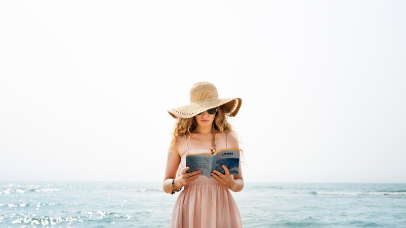 mulher na praia lendo